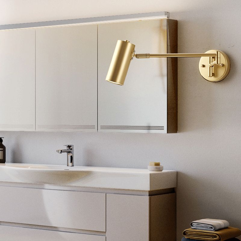 Brady Gold cylindrical wall light beside a mirror above a sink
