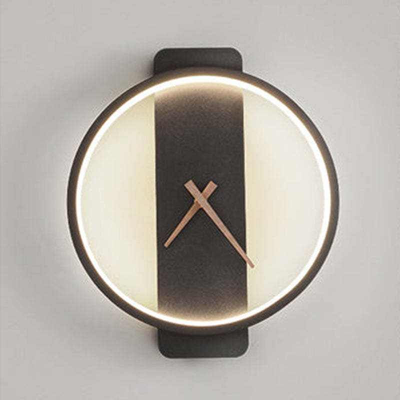 Closer front view of a Black round wall light, illuminated inner outline, Brown hands and extended vertical backplate