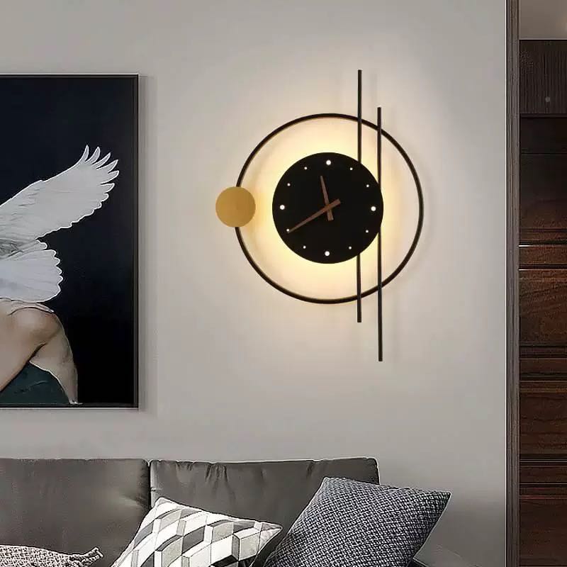 Black illuminated clock with a gold disc beside framed artwork