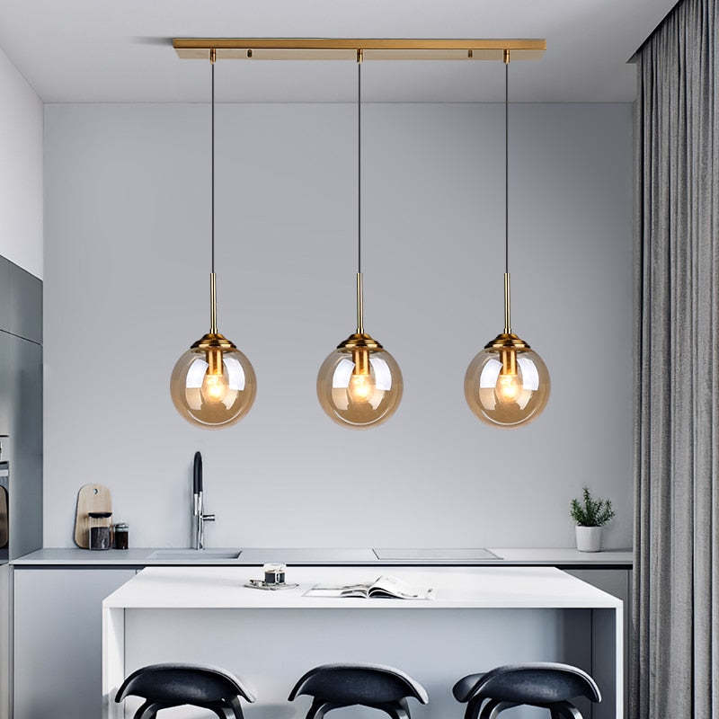 Valentina Amber Glass three-light linear pendant above a kitchen island