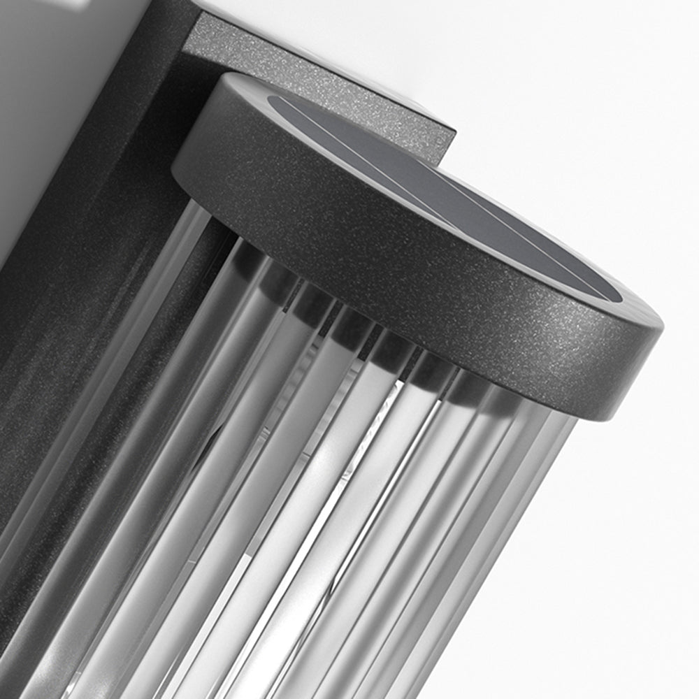 Dark circular top insert and ribbed side detail of the Orr wall lamp