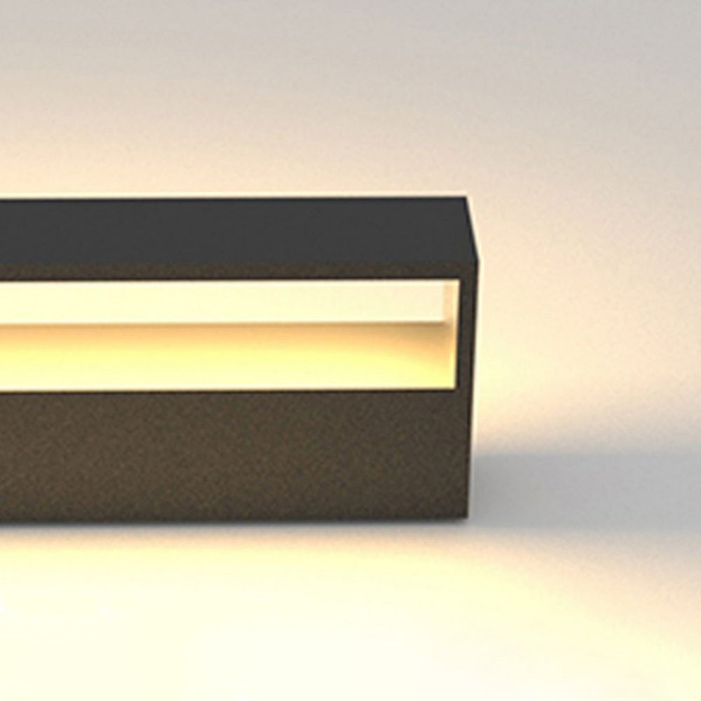 Close-up of a lit black frame arranged horizontally, showing the narrow opening and warm-looking wall glow