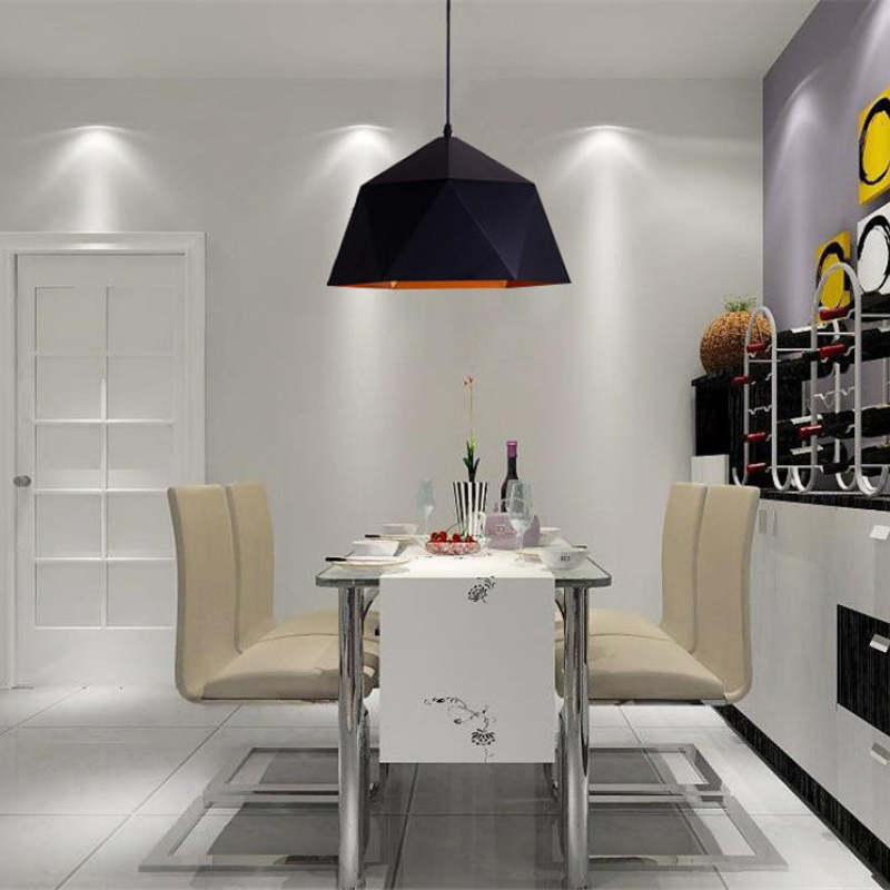 Single black faceted pendant over a dining table with cream chairs beside a wall-mounted wine rack