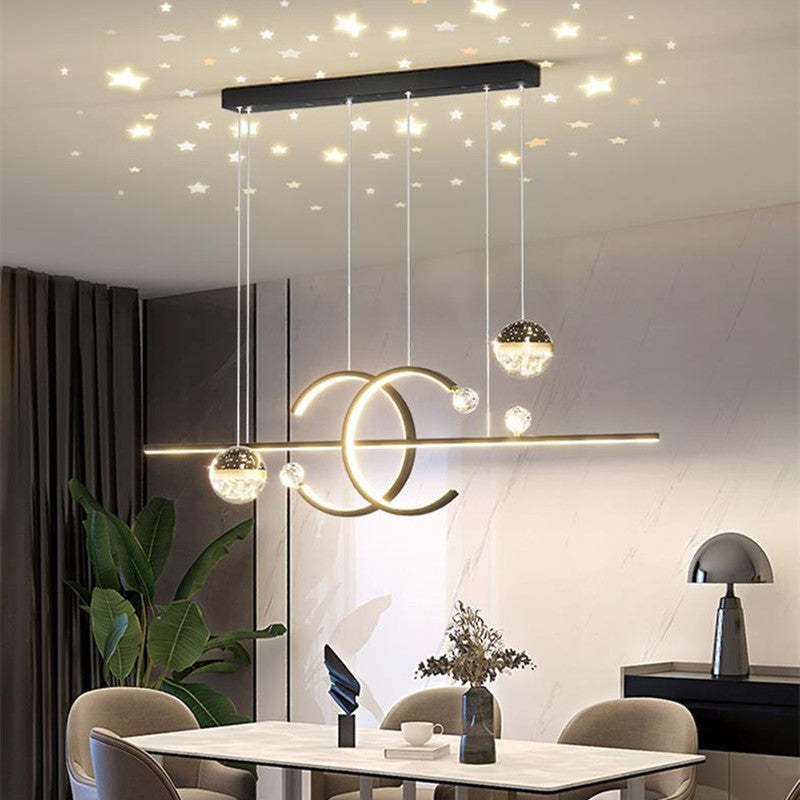 Gold-tone Madina pendant above a table in a grey room, with a star pattern pictured overhead