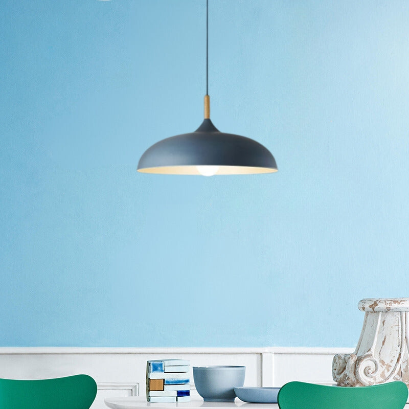 Blue wide dome pendant above a white table with blue bowls and green chairs