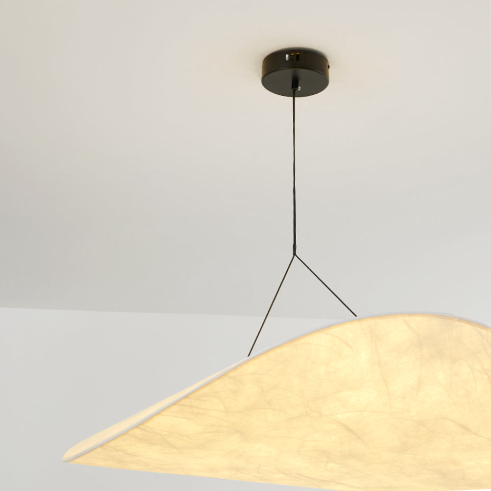 Black ceiling canopy and forked hanging wires above a glowing curled Renée shade