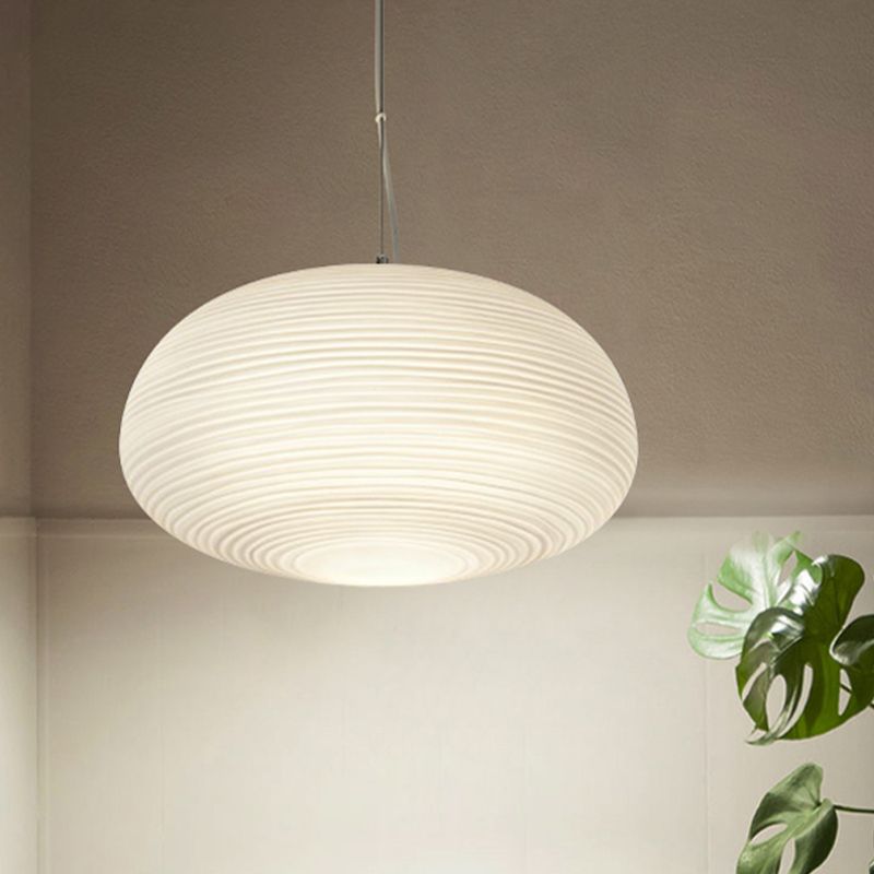 Renée Shape C wide flattened white ribbed pendant beside foliage