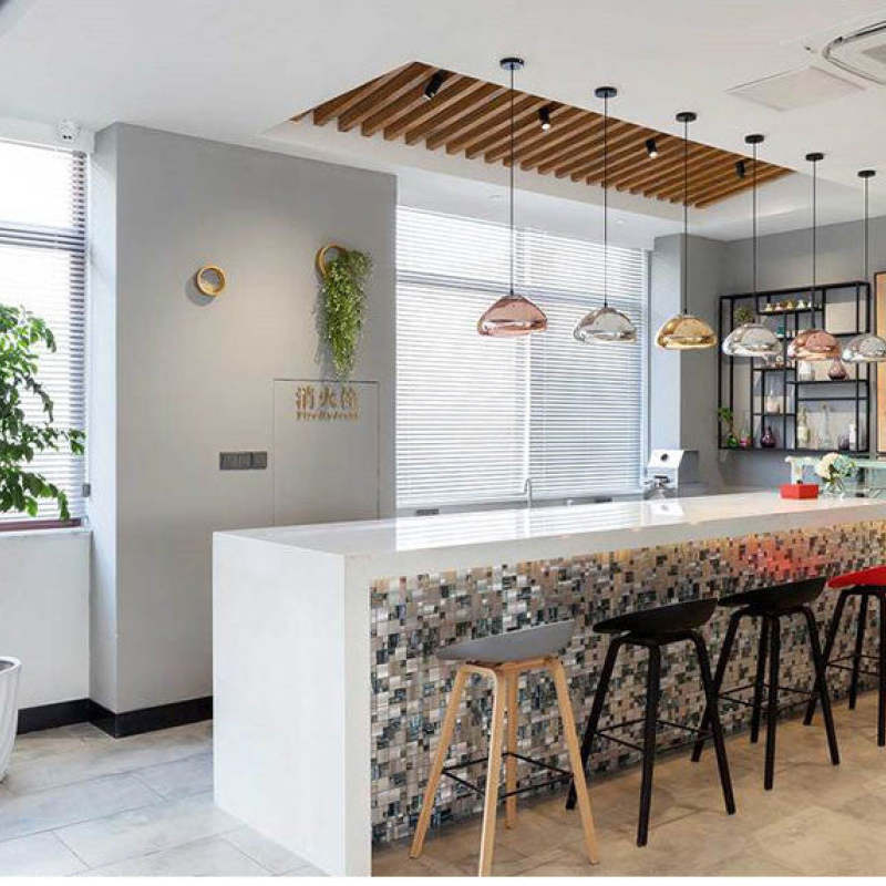 Mixed-finish dome pendants in a row above a white bar counter