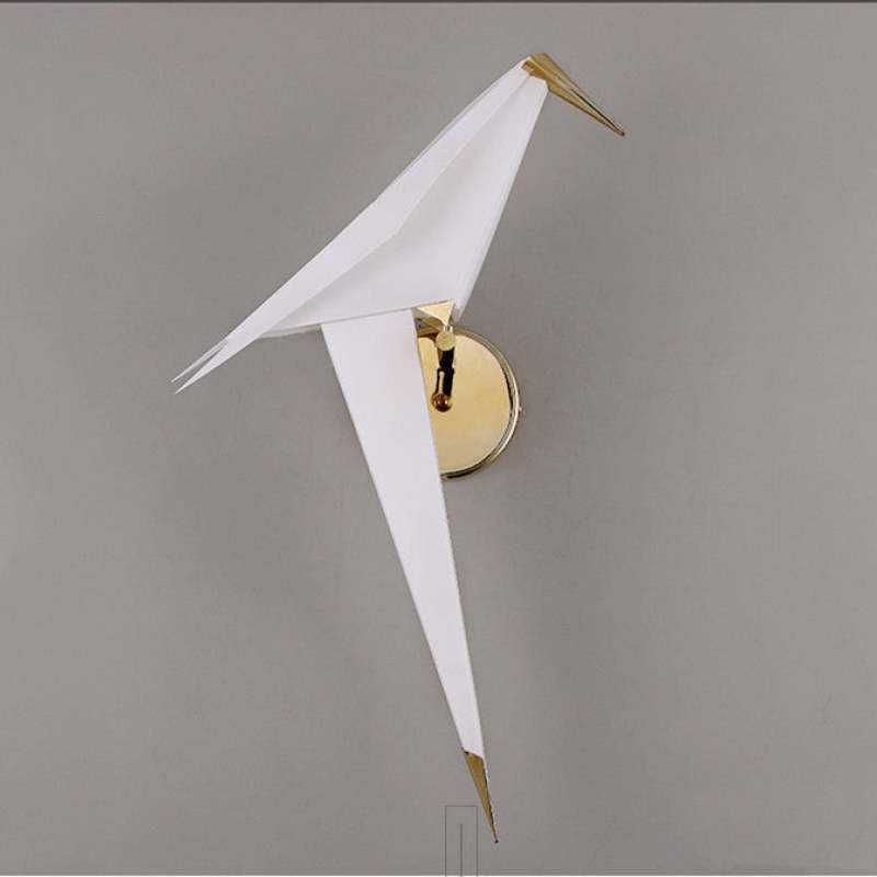 Unlit white Clifford bird in side profile, showing angular wings, long tail and round gold-tone wall plate