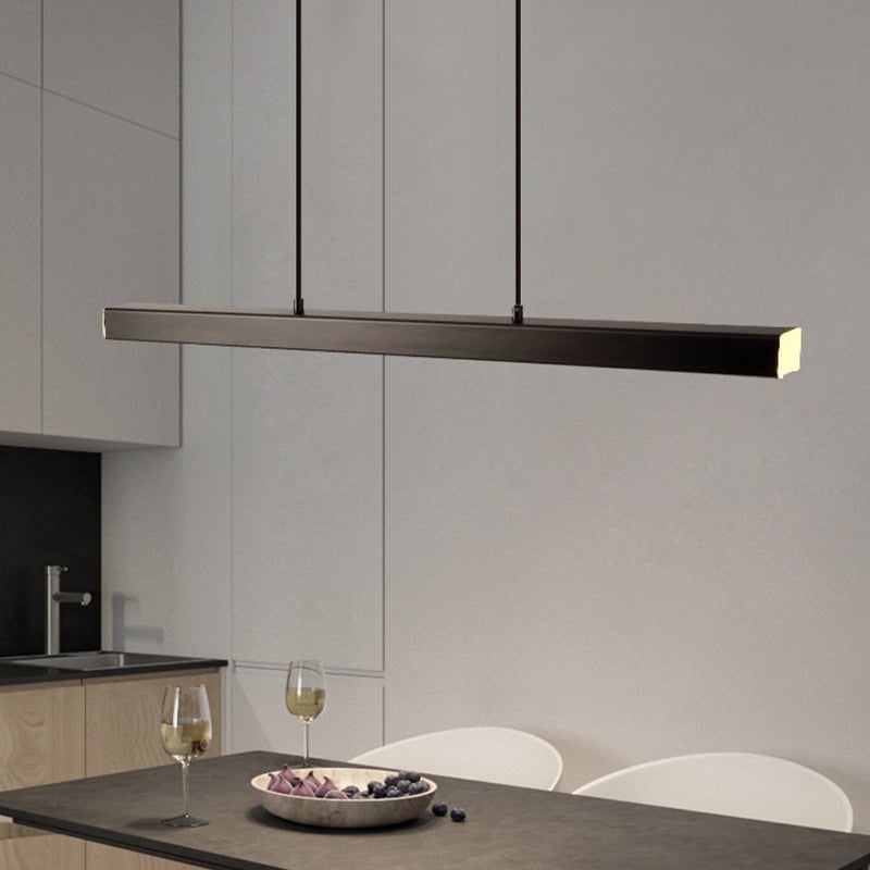 Black Edge pendant angled above dark dining table with wine glasses and fruit plate, white chairs and kitchen cabinets