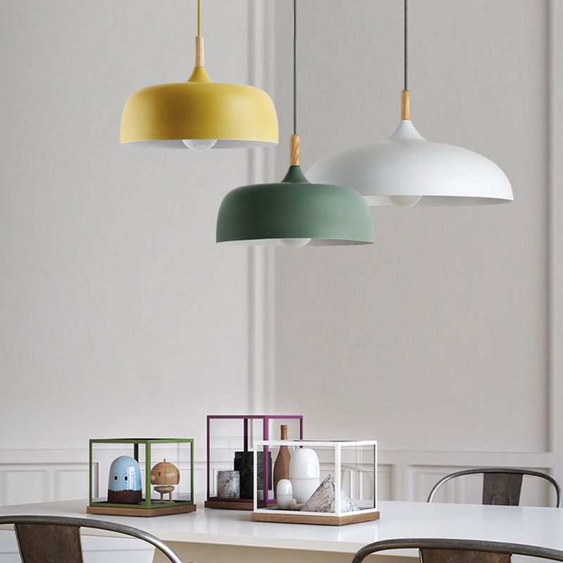 Yellow and green deep domes with a white shallow dome hanging above a dining table with display boxes