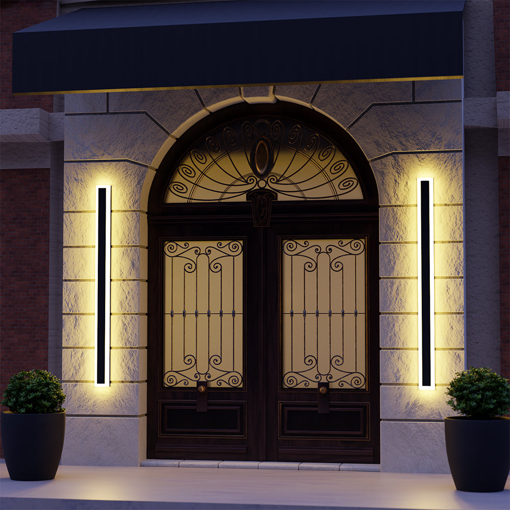 Two illuminated Edge wall lights flanking an arched entrance with decorative double doors