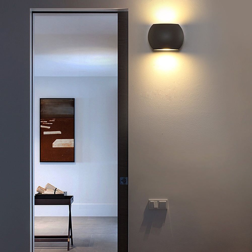 Black Style A Orr wall lamp casting light above and below beside a door