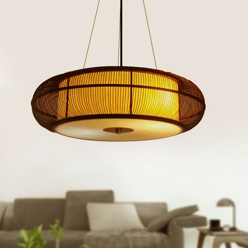 Close-up of a glowing Ozawa woven drum shade above a sofa.
