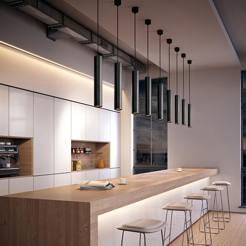 A row of black Edge cylinder pendants above a long kitchen island.