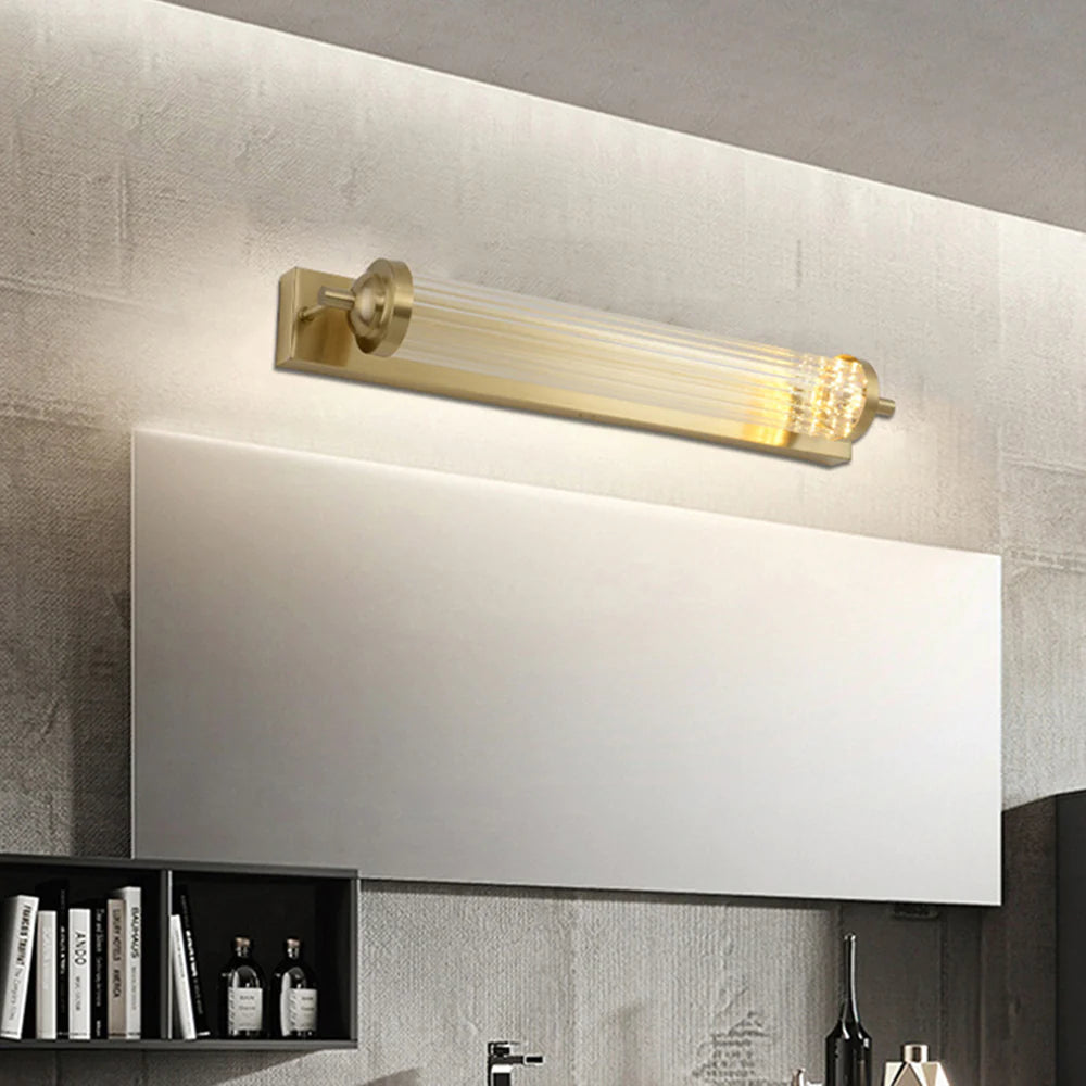 Illuminated cylindrical crystal lamp above a wide rectangular mirror.