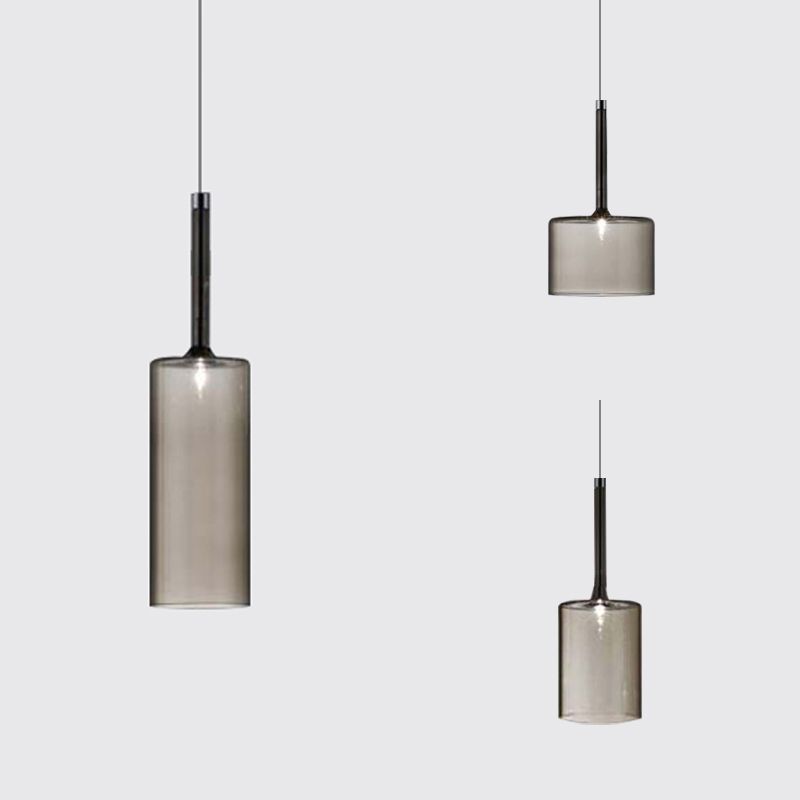 Three gray glass cylinder pendants with long necks arranged at different heights