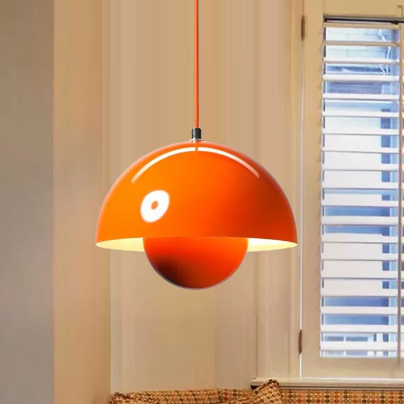 Orange half-dome and lower sphere pendant by a window