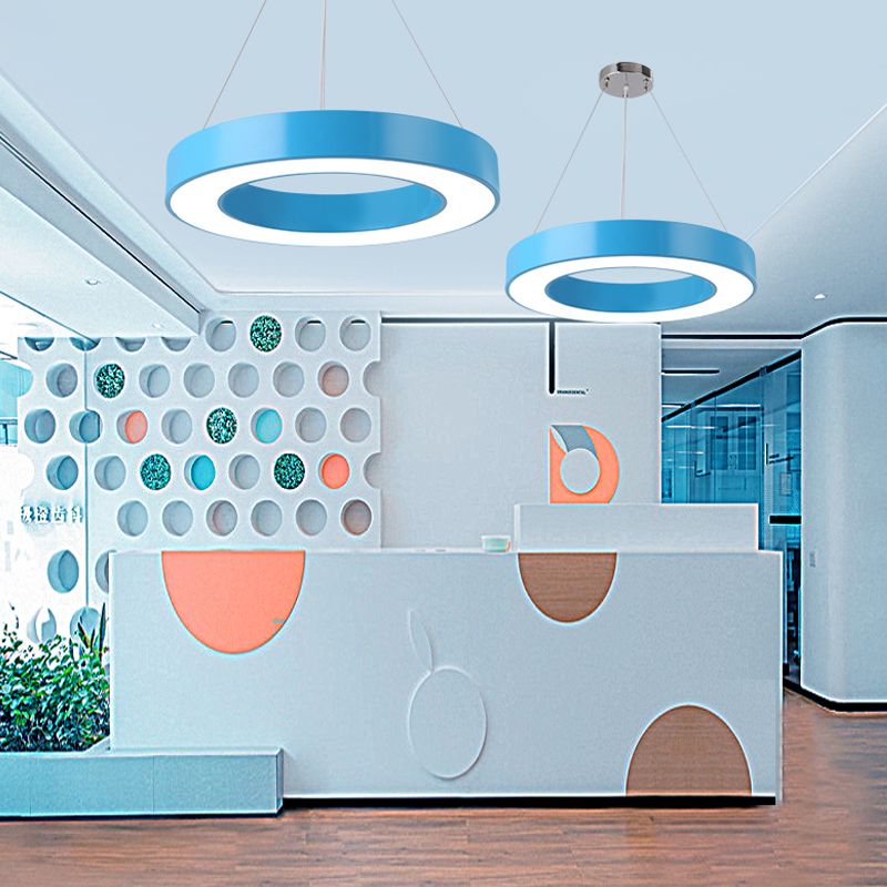 Two blue Morandi ring pendants above reception-style counter with circular cutout partitions and wood floor