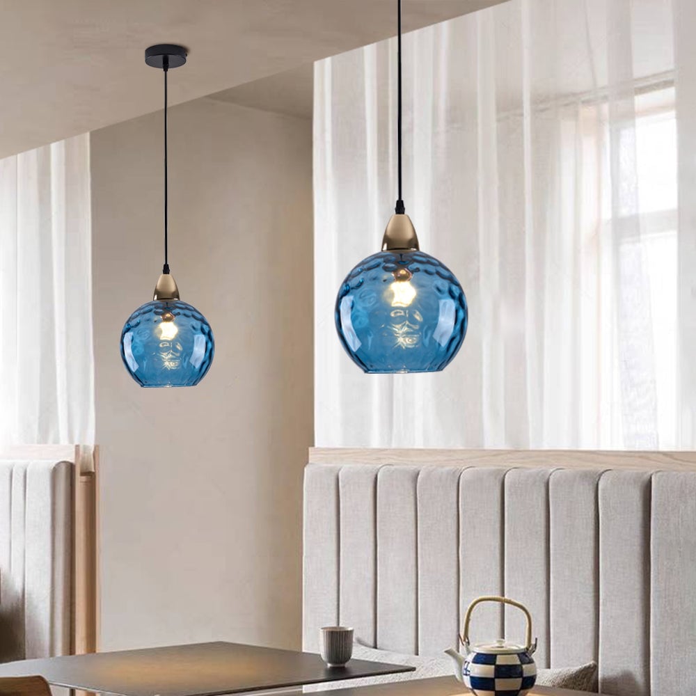 Blue rippled glass globe pendants above a banquette with black ceiling plate