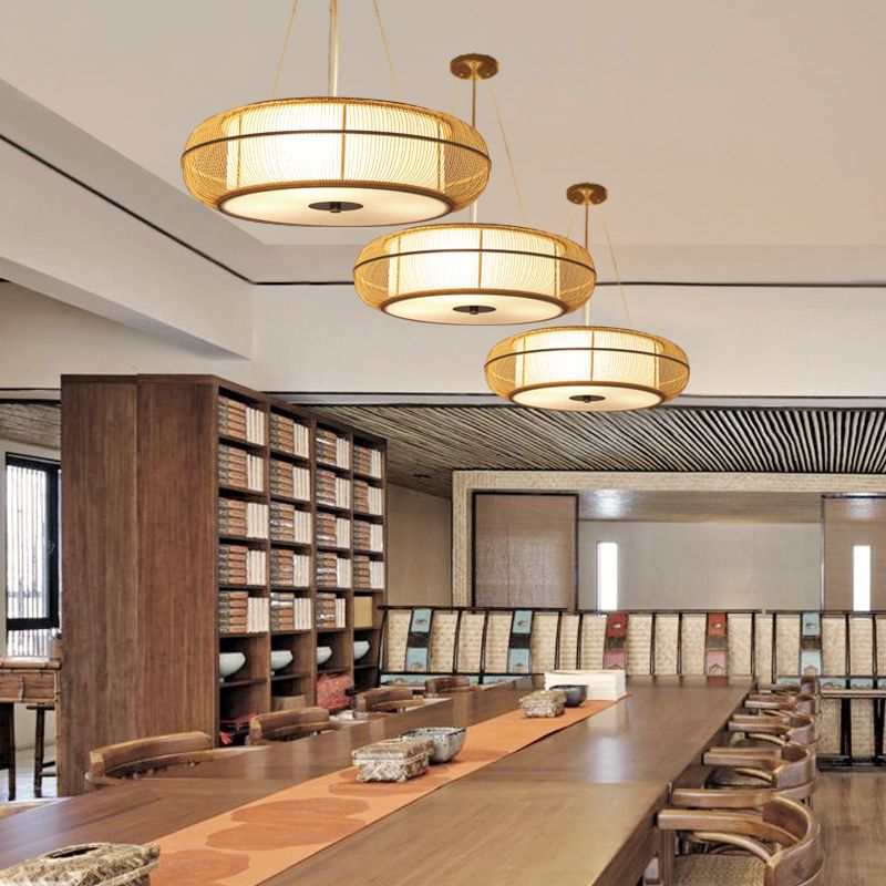 Three wood-toned Ozawa pendants above a long dining table.