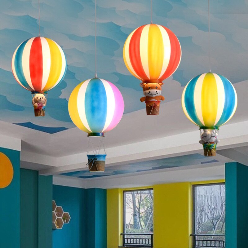 Four striped balloon pendant lights at different heights in a blue and yellow room, with toys pictured in some baskets