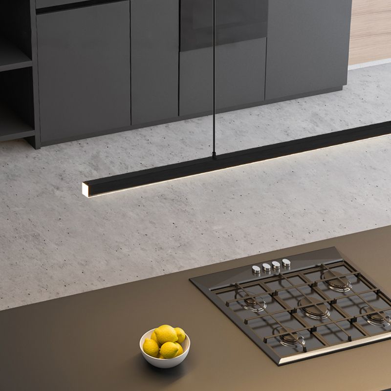 Top view of black Edge pendant above kitchen island with gas hob, lemons and dark cabinets