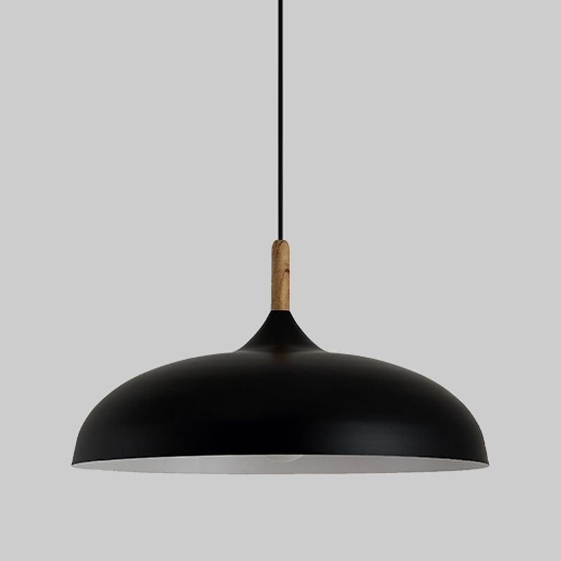 Close view of the wide black dome pendant with a pale interior and wood-grain-look collar