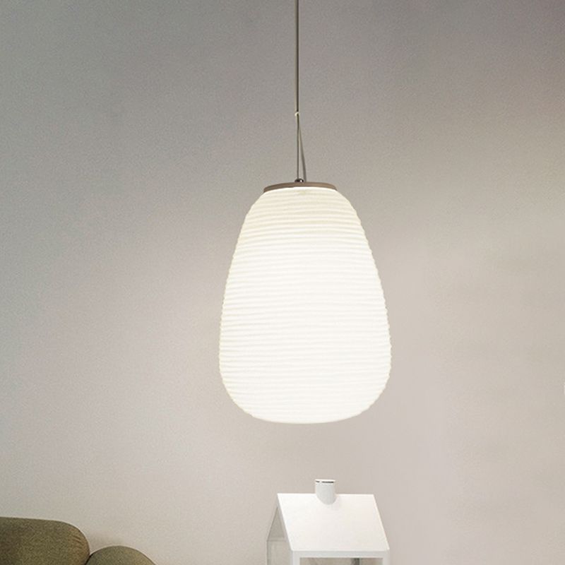 Renée Shape B tall white ribbed pendant on a pale wall above a house-shaped ornament
