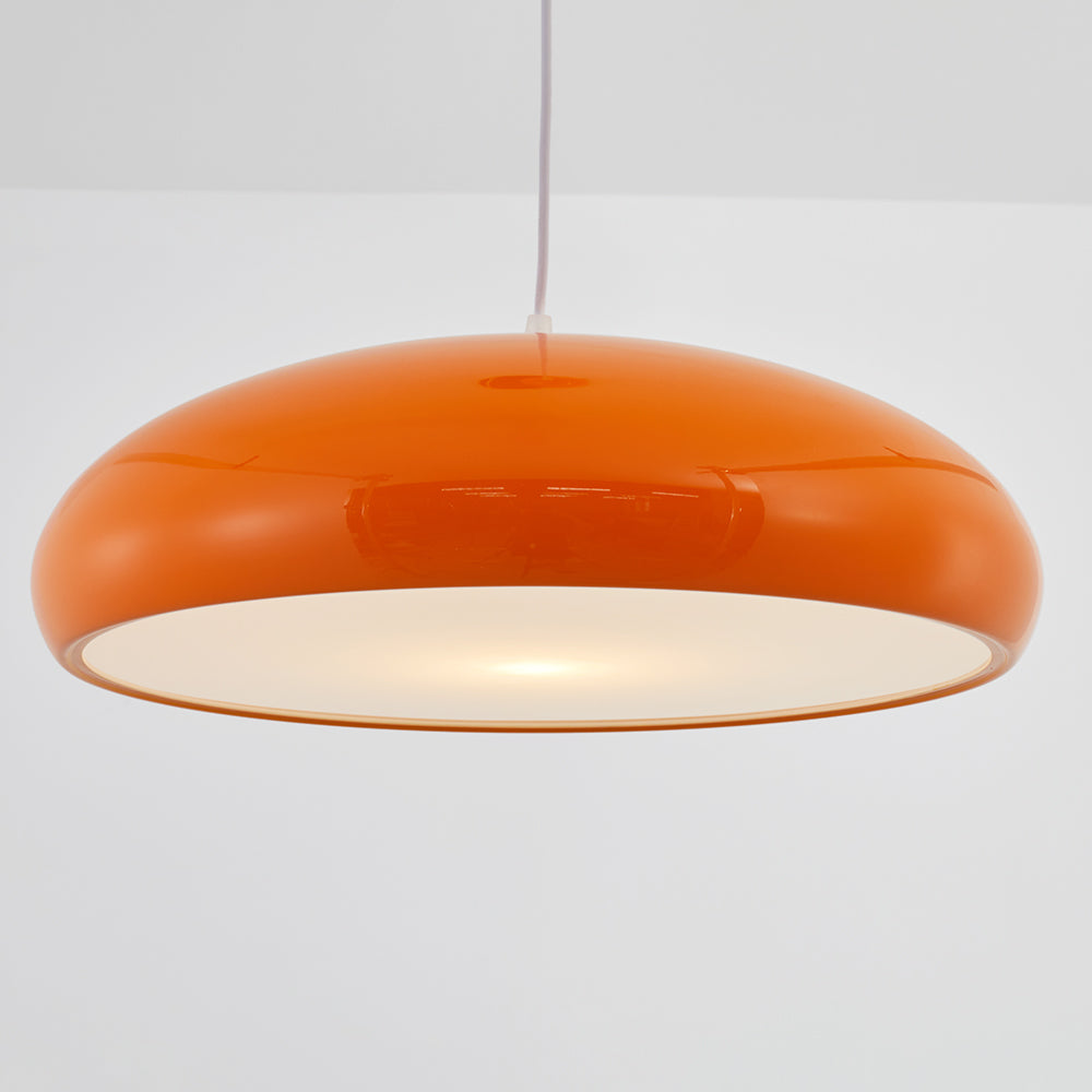 Close side view of the glossy orange dome shade and pale underside