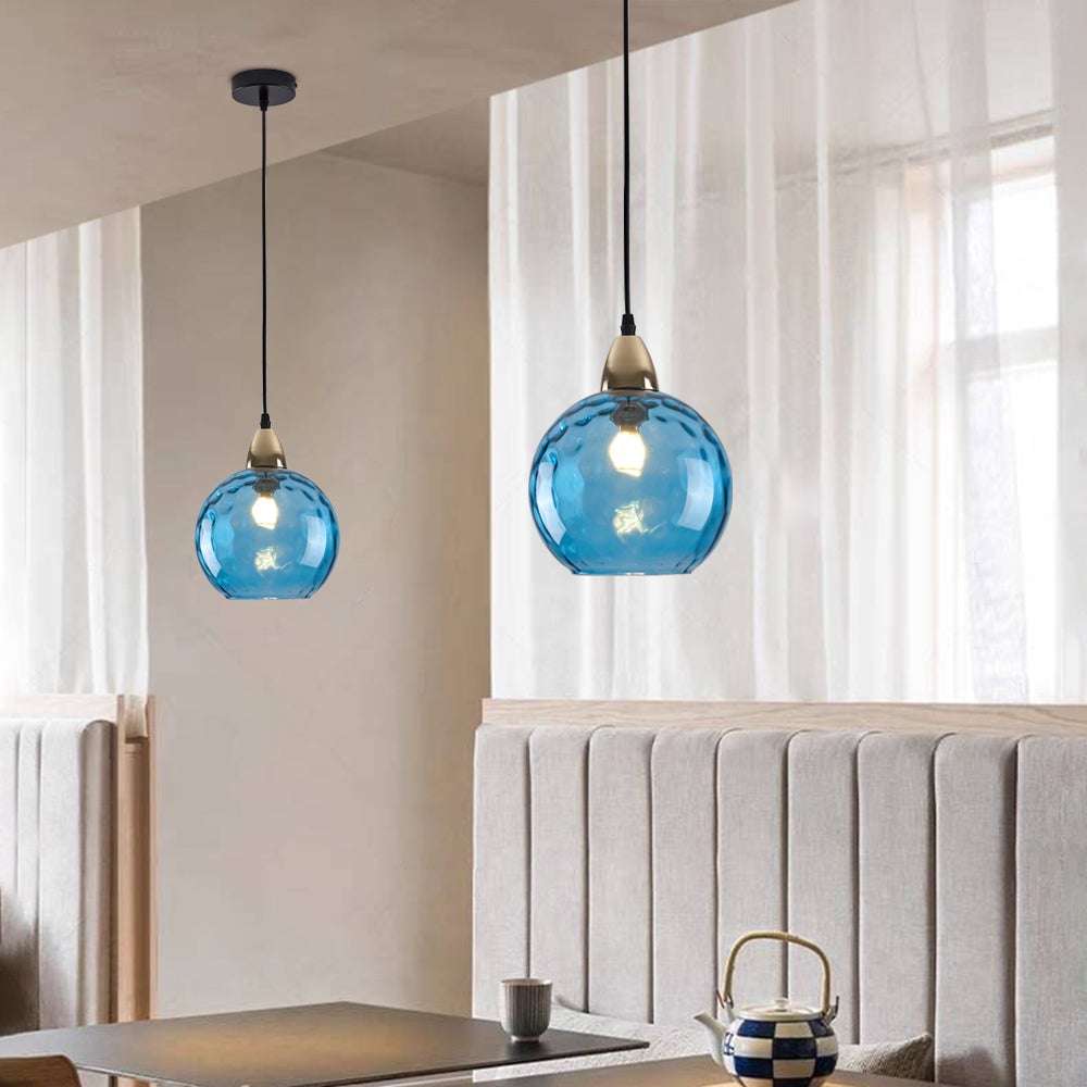 Blue glass globe pendants above a banquette with black ceiling plate