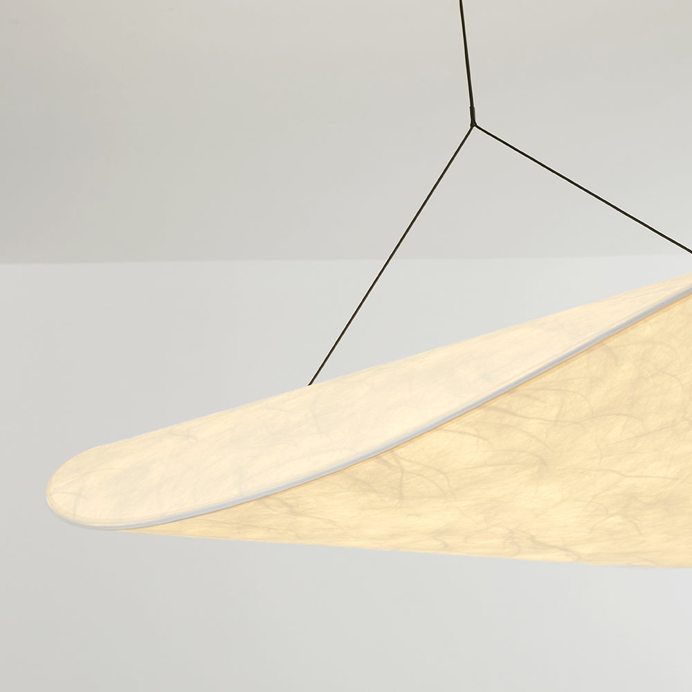 Close-up of the illuminated shade texture, curved edge and one black suspension attachment