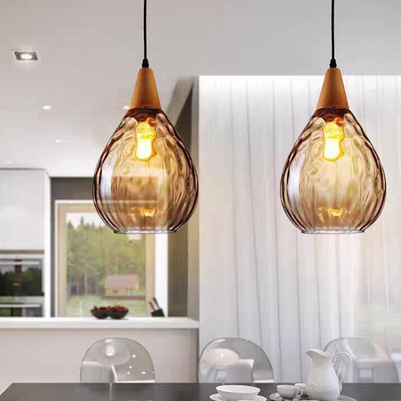 Two wide amber Avi pendants above table with teapot and cups, clear chairs and window