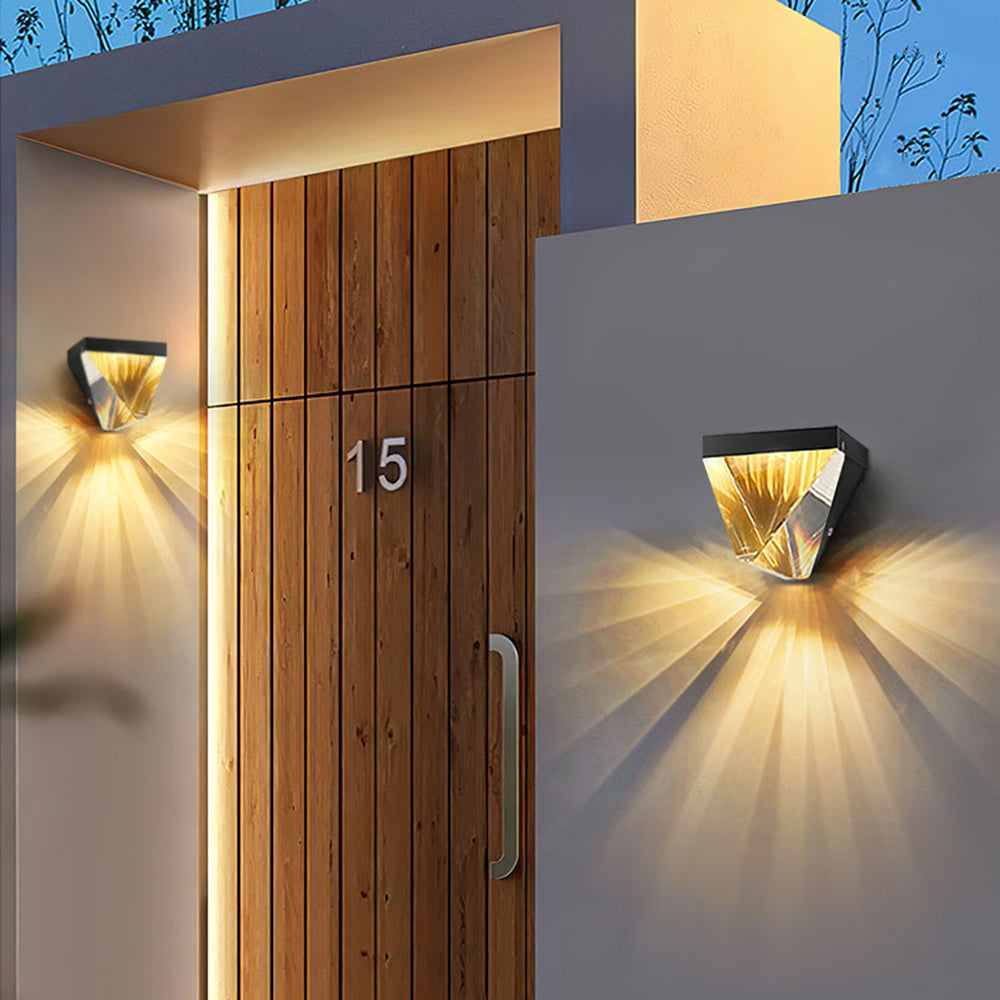 Black Orr wall lights casting warm rays beside a wooden entrance door
