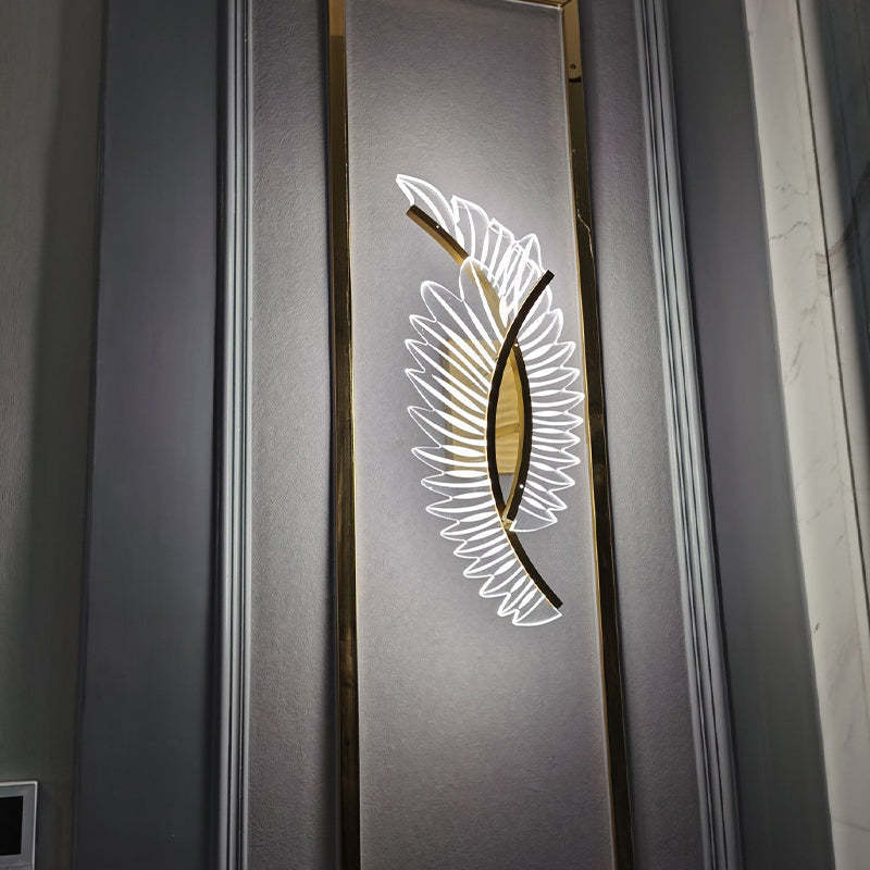 Gold-tone Kristy overlapping wing wall light on a framed gray wall