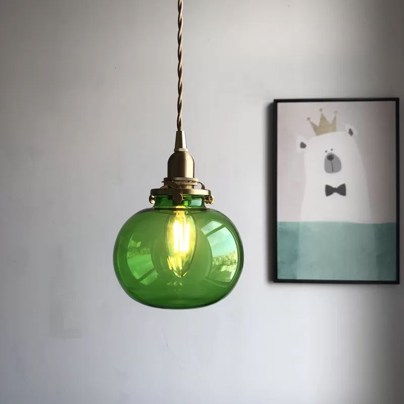 Green glass globe pendant beside framed wall art