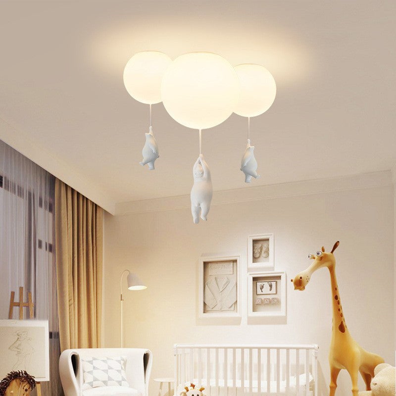 Three bear balloon lights on a nursery ceiling above a crib and giraffe decoration