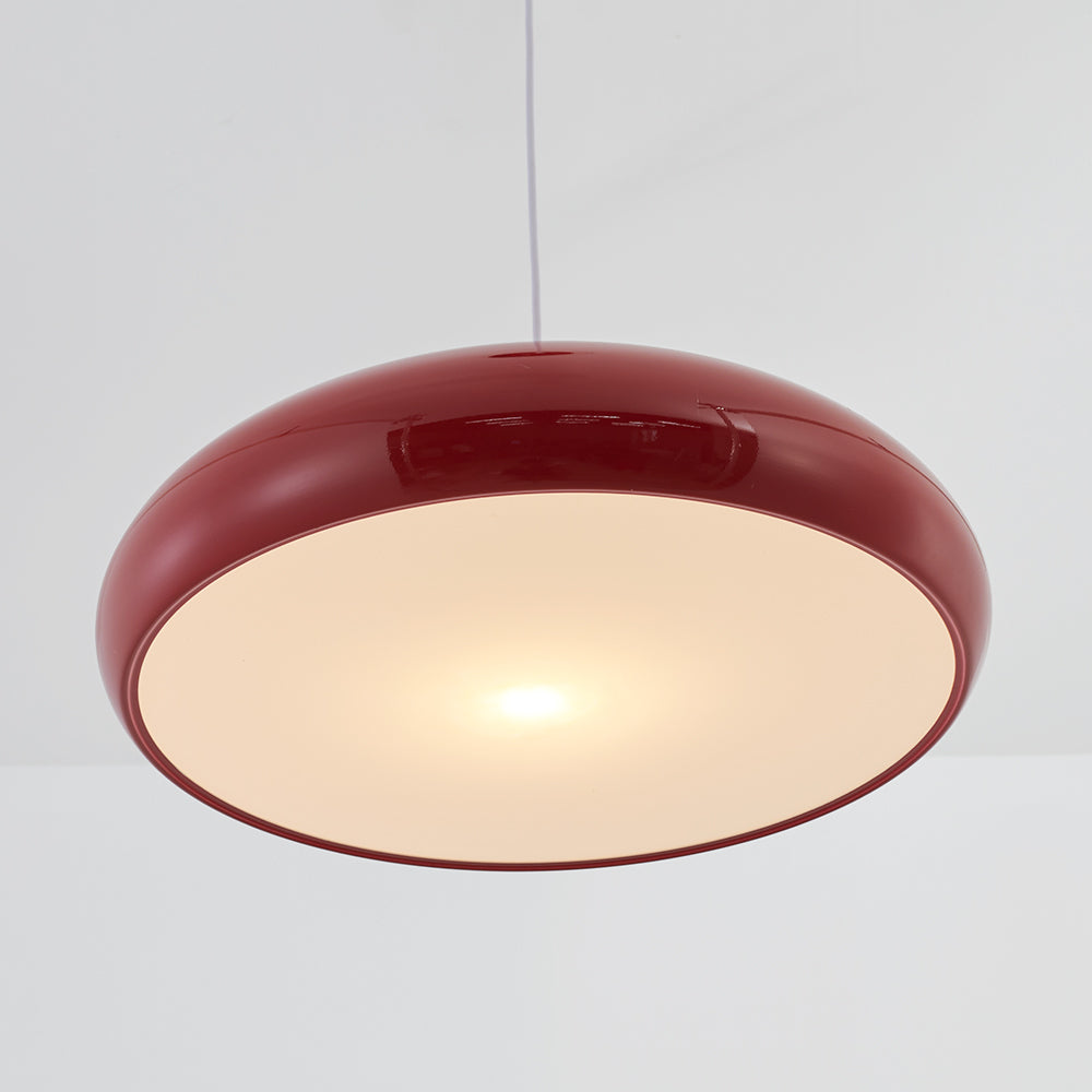 Wine-red dome pendant viewed from below with a light cord and broad pale glowing underside