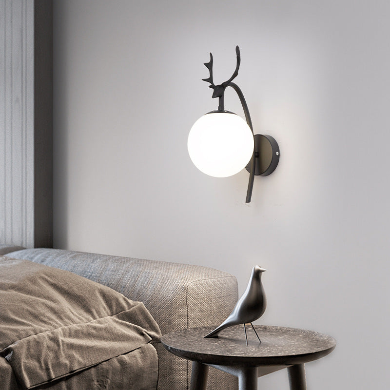Black Valentina with white globe above a sofa and side table with a bird ornament