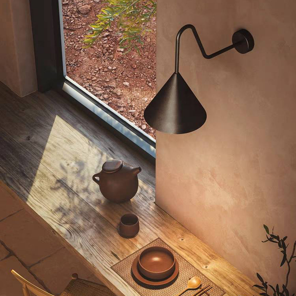 Carins Black H 16.2 curved-arm cone wall light beside a window and table with ceramic teapot and tableware