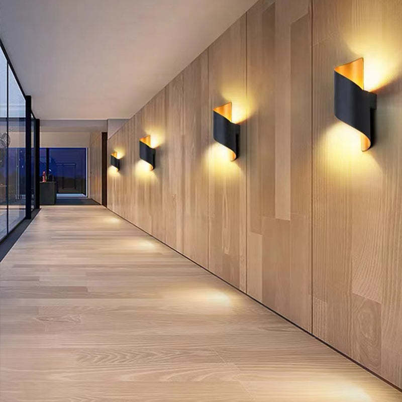 Four black and gold wall fixtures with upward and downward glow along a timber-lined corridor