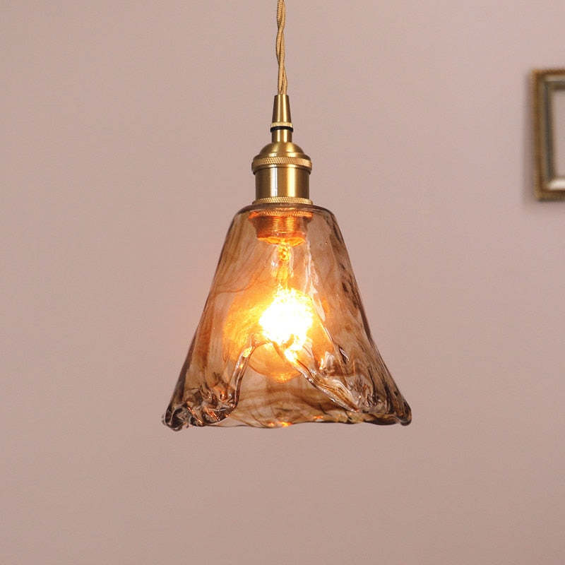 Tall tapered amber glass pendant with an irregular rim and brass-tone fitting