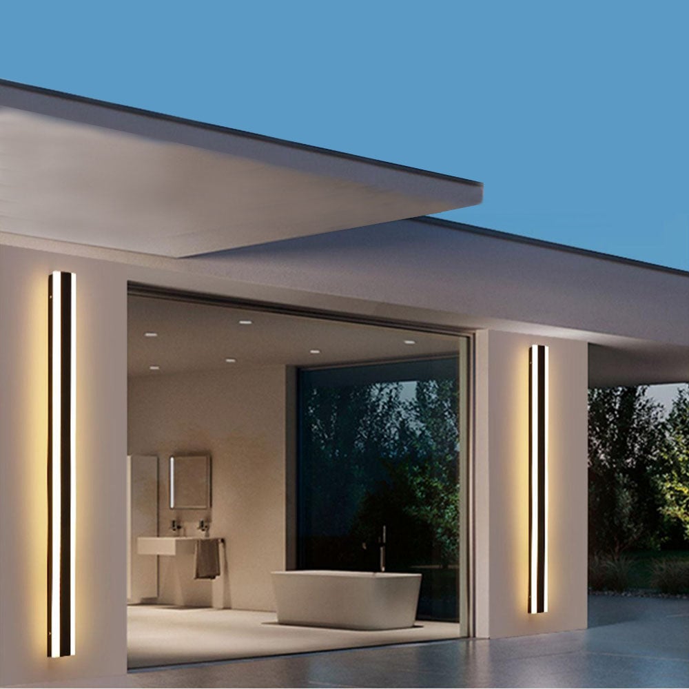 Two Black Orr illuminated-edge wall-light bars beside a large window overlooking a bathroom