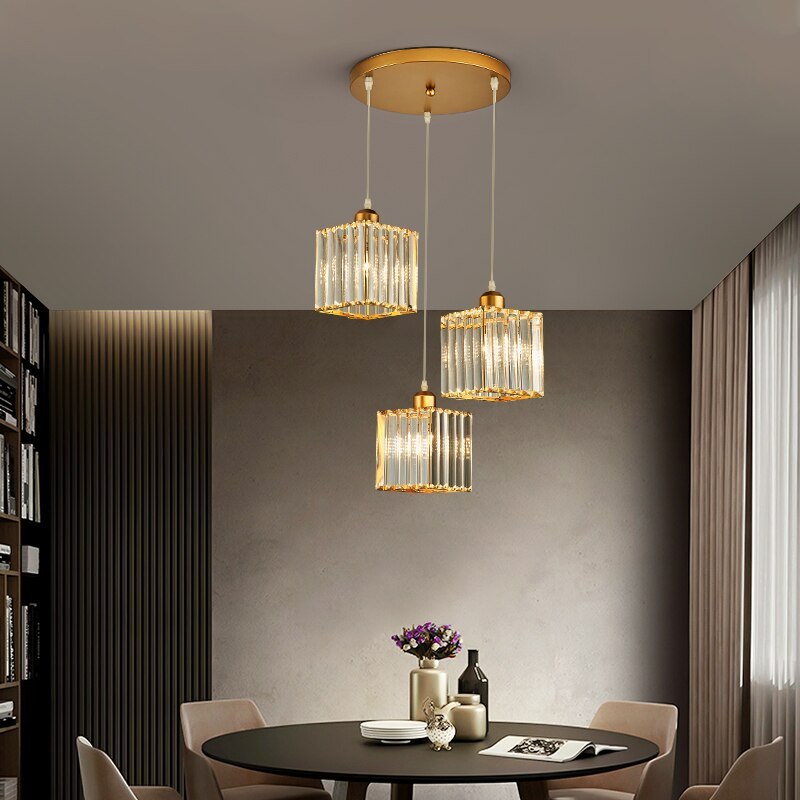 Three gold Herbert square glass shades staggered below a round canopy above a round dining table