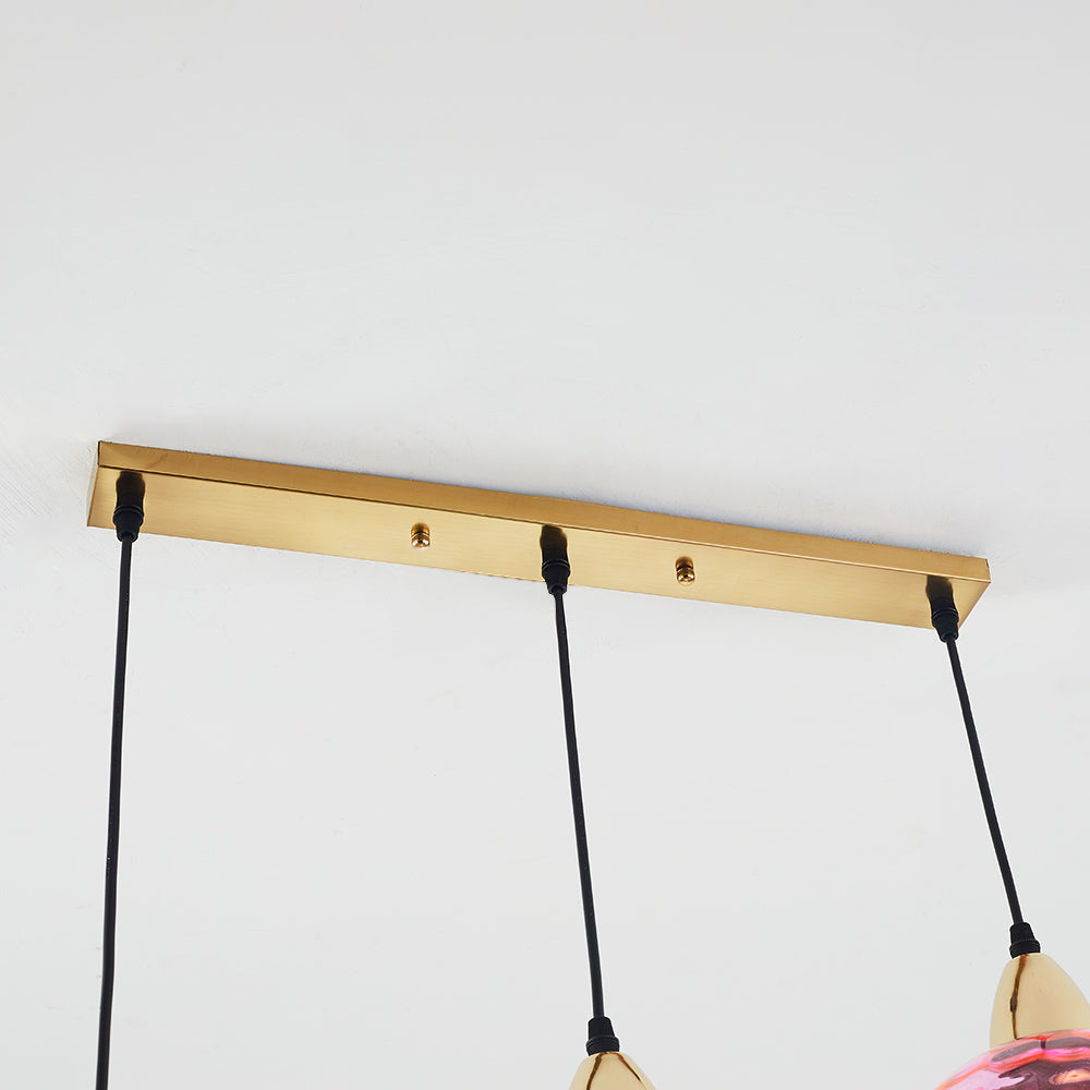 Close-up of the gold-tone rectangular canopy with three black cord outlets and two fasteners