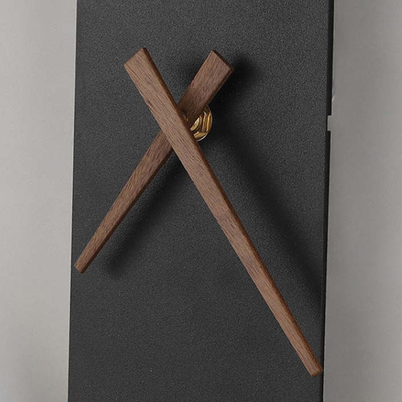 Nielsen closeup of brown wood-grain-looking clock hands and a gold-tone hub on a dark textured strip