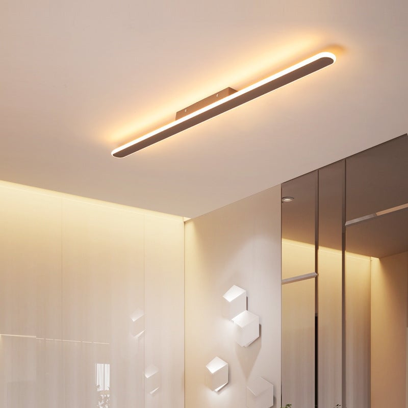 Long illuminated gold-colored light bar near a ceiling