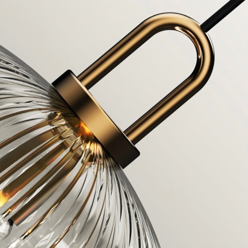 Close view of gold-toned loop joining suspension to ribbed glass shade