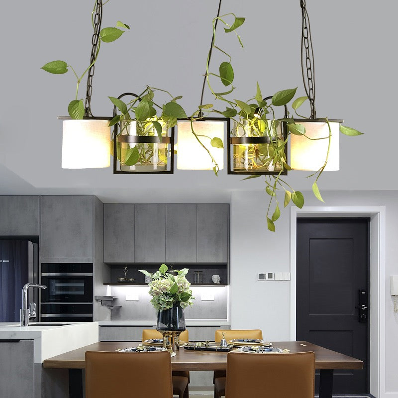 Nest three-shade pendant with greenery above a kitchen island