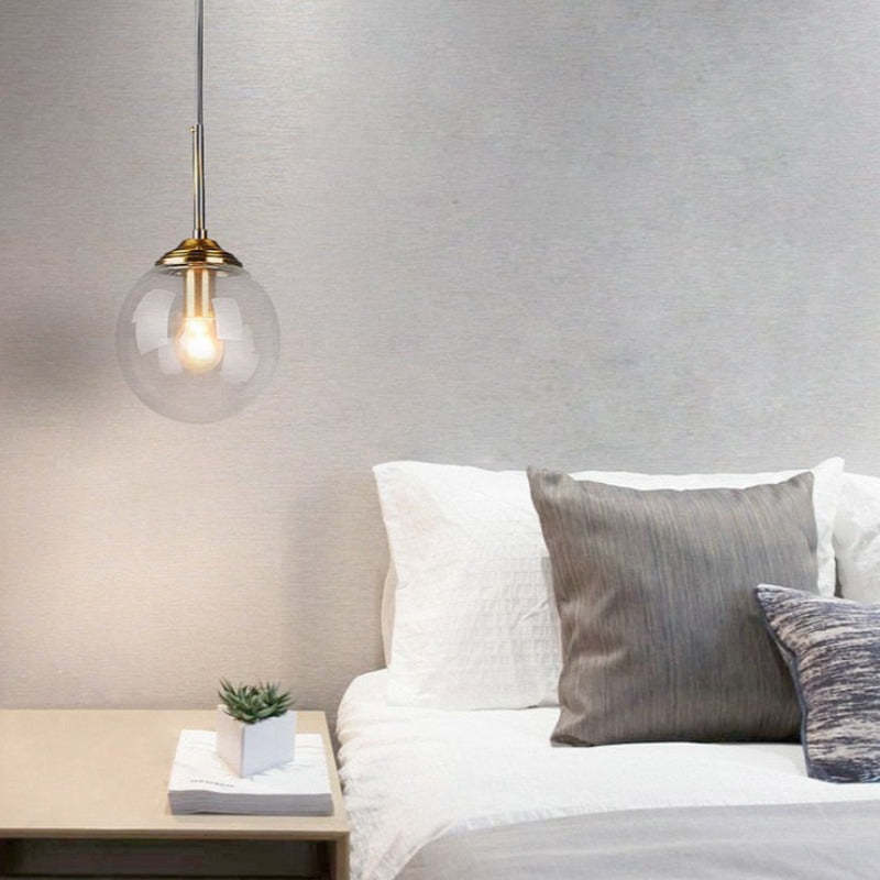 Valentina Clear Glass single globe pendant beside a bed